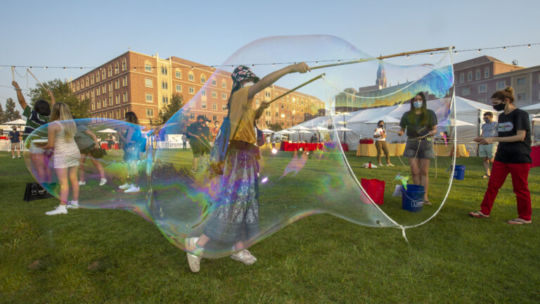 A female student makes large bubbles during the residential new student welcome dinner.