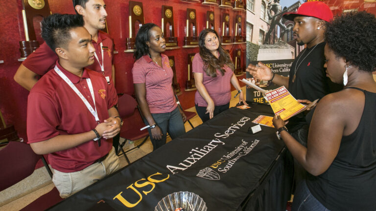 USC Auxiliary Service representatives working at a booth for a job fair.