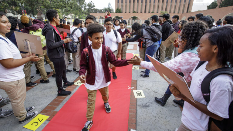 Elementary school students walking the red carpet into USC to participate in the USC McMorrow Neighborhood Academic Initiative Saturday Acadmey kickoff