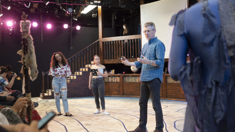 Driector instructing students in a performance of 