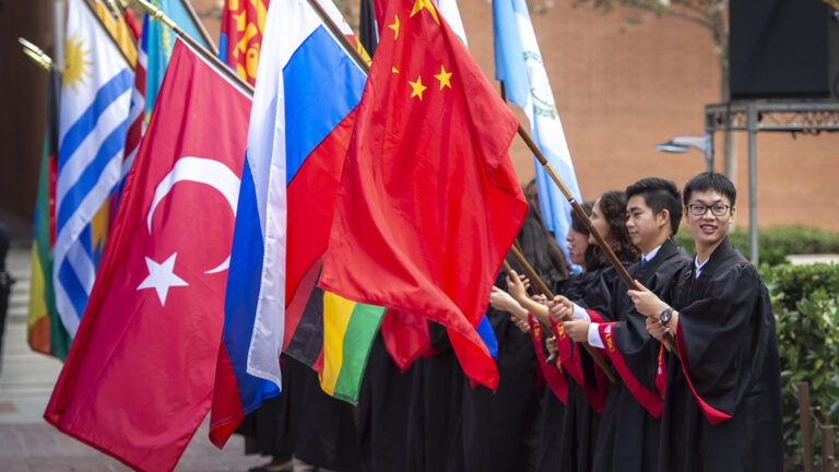 Students holding international flags in a line