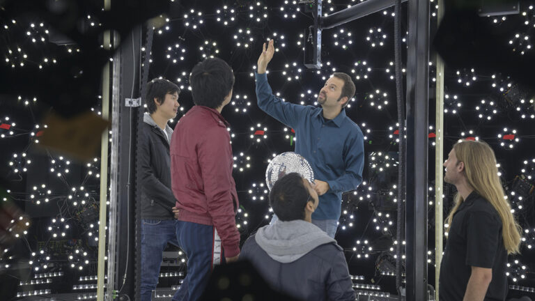 Teacher shows students the lgith stage used to create virtual characters.