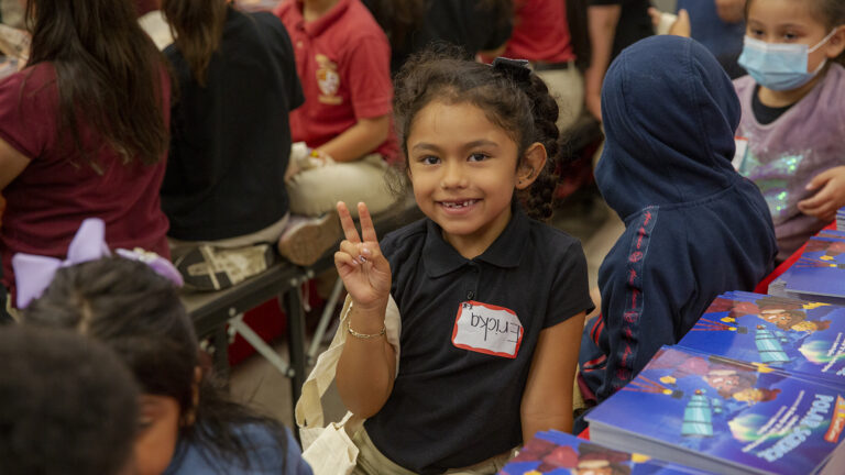 Child making peace sign at camera