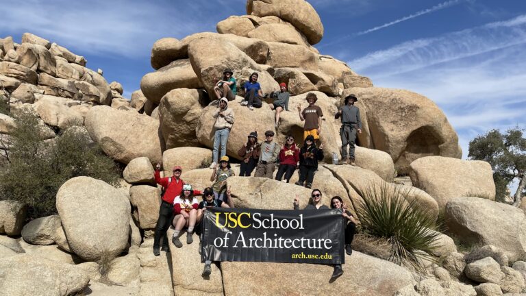USC School of Architecture students pose for picture in front of a rock formation.
