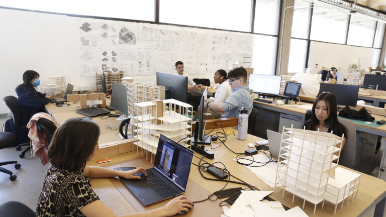Various students sit in class during an architecture class.