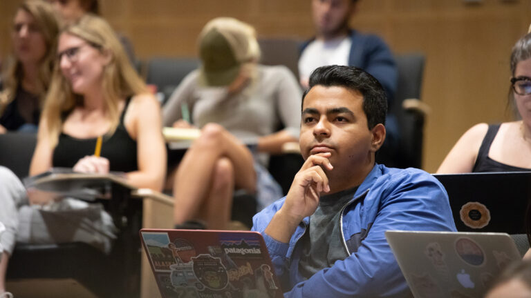 A USC student listens attentively in an auditorium.