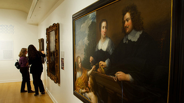 Two people looking at a painting in the Fisher Museum.