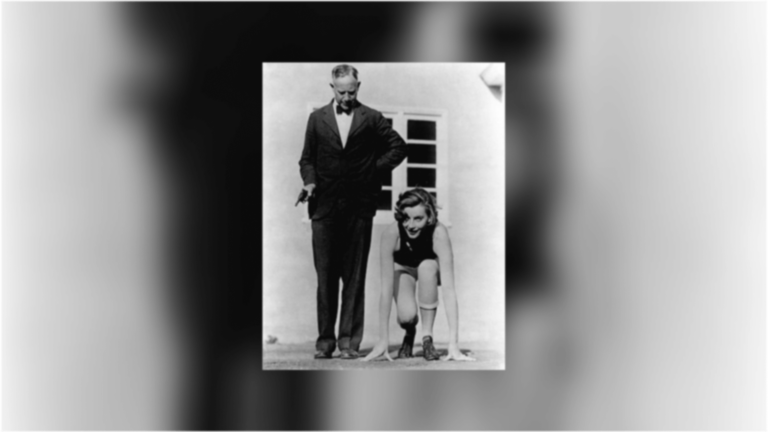 Greta Garbo posing in a USC track uniform next to coach Dean Cromwell holding the starter's gun