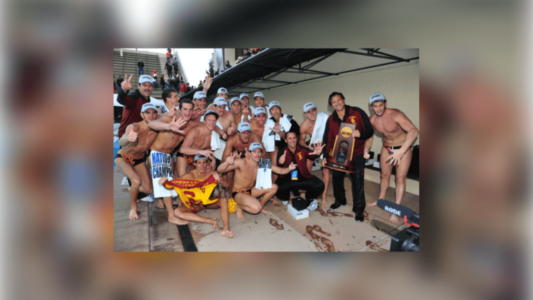 The men's water polo team posing with their trophy.