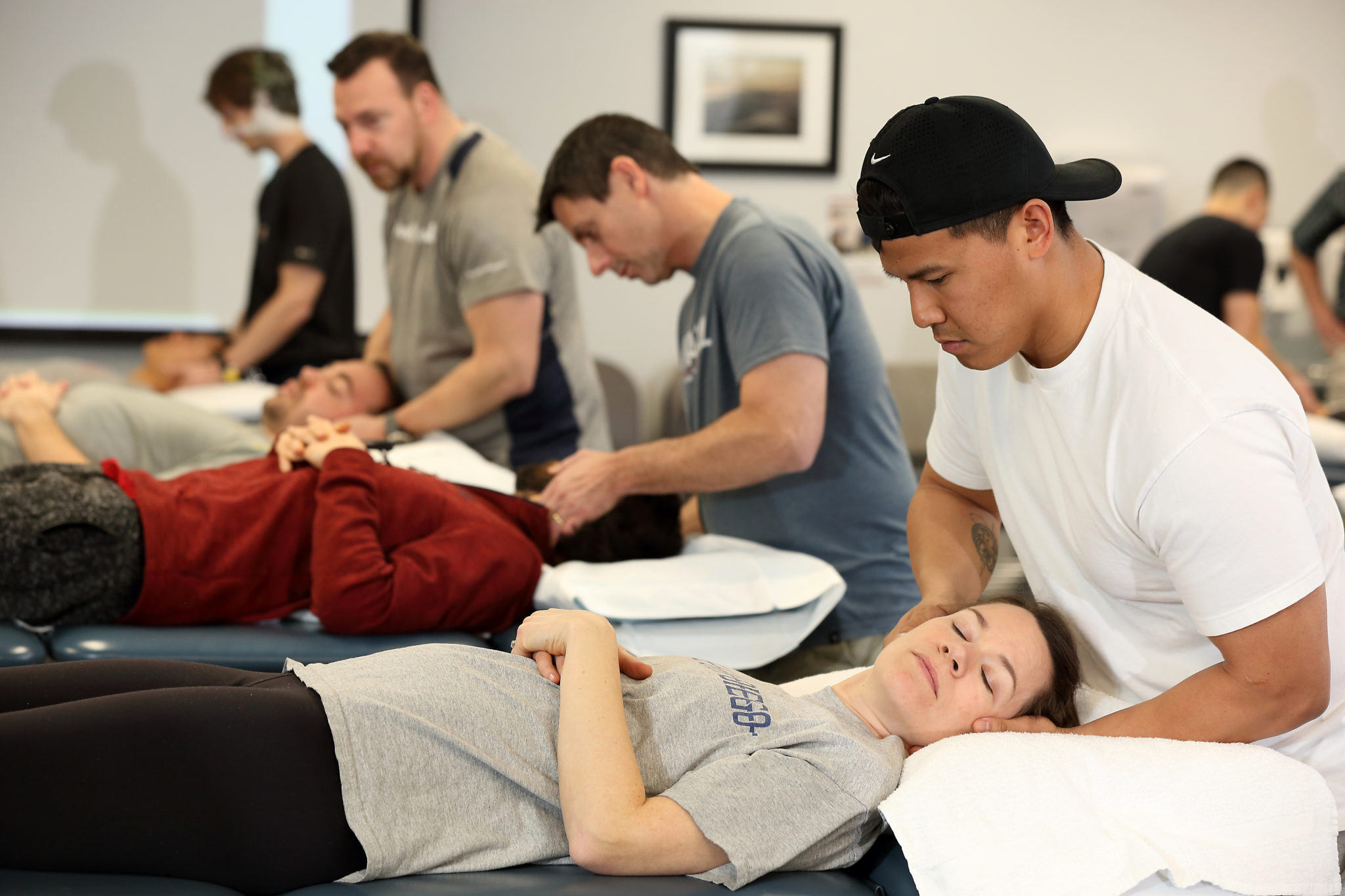 Physical therapists stretching and moving patients' necks for rehabilitation.