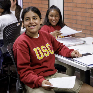An elementary student smiles at the camera duringUSC McMorrow Neighborhood Academic Initiative Saturday Academy kickoff