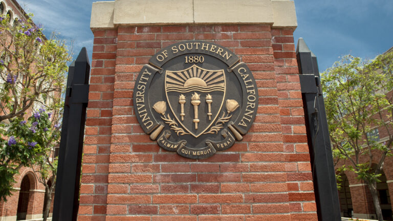 The USC seal on a column of a gate on the USC campus.