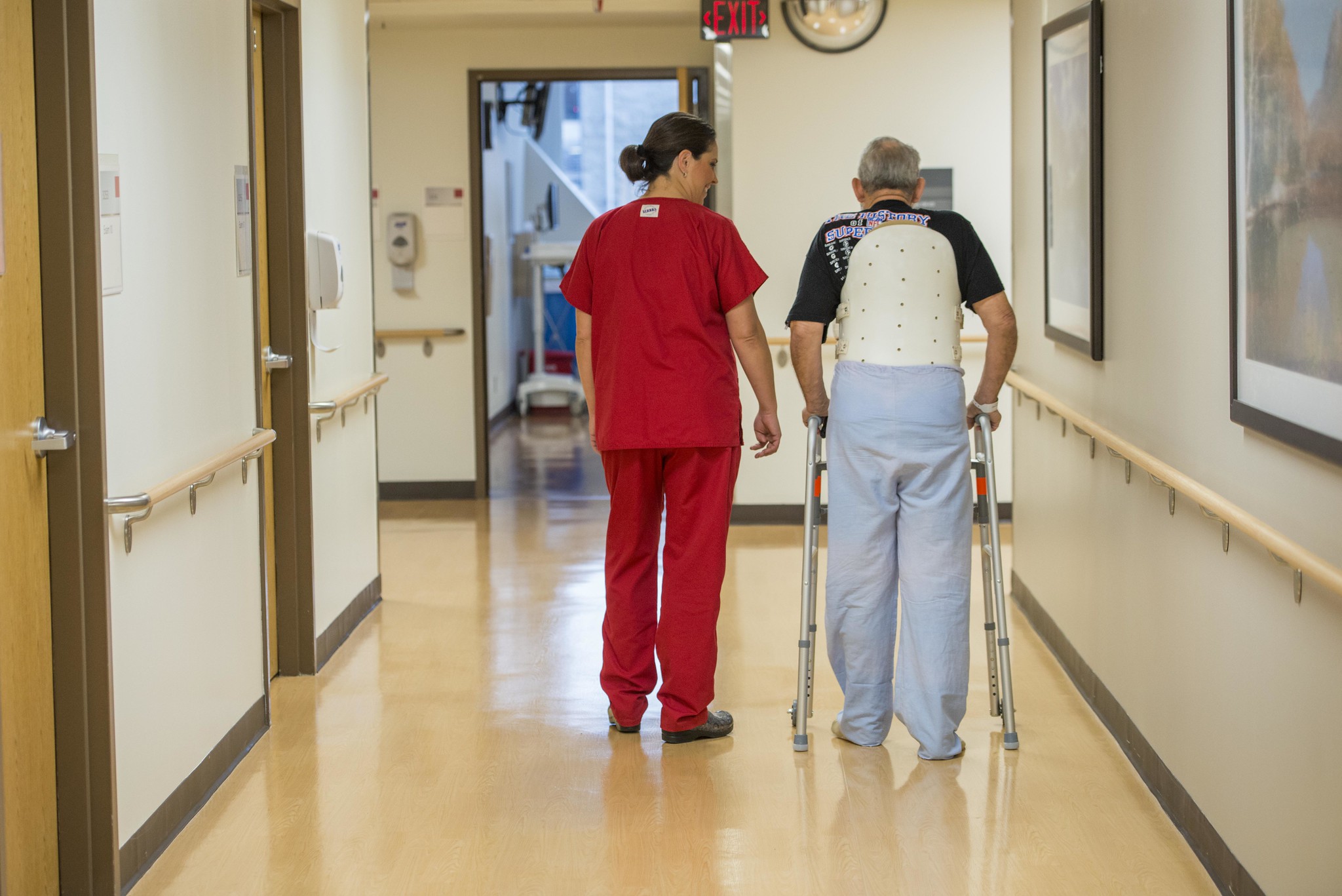 A nurse next to an elderly man with a walker