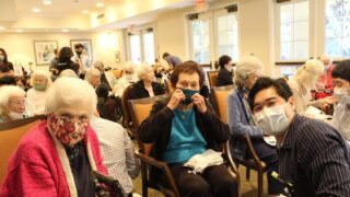 Smiling senior citizens sitting down in chairs