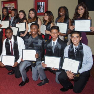 Students from the TRIO program holding up their graduation certificates.