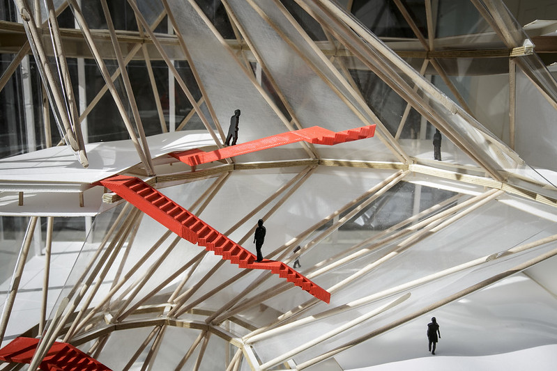 Architectural design with red floating stairs and wood supports