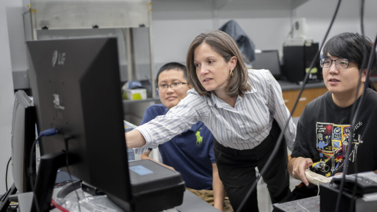 Professor Andrea Armani teaching students in front of a computer