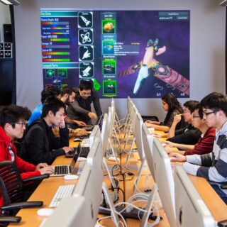USC Viterbi School of Engineering students work at rows of computers and collaborate.