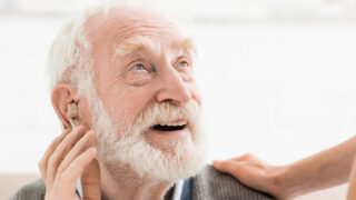 Older man using hearing aid