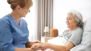 Caregiver with older person in a bed